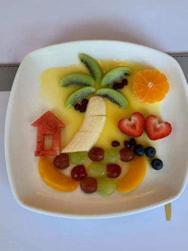 a plate of fruit with a banana and a palm tree at The Bahamas in Torquay