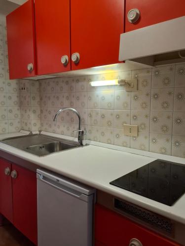 a kitchen with red cabinets and a sink at Residence Napoleon - MV in Procchio