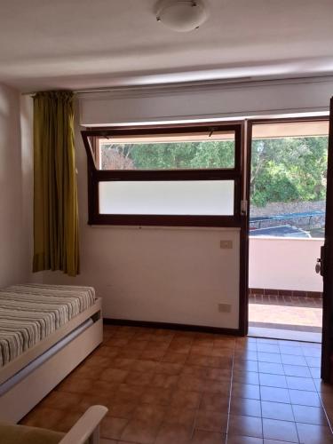 a bedroom with a bed and a large window at Residence Napoleon - MV in Procchio