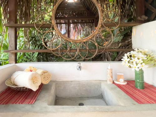 a bathroom with a sink with towels and a mirror at Finca Exótica in Carate