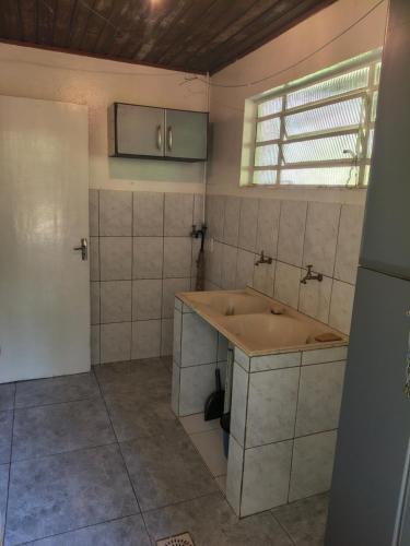 a bathroom with a large sink and a window at Refúgio da Serra - com lareira - 900m do Capivari in Campos do Jordão