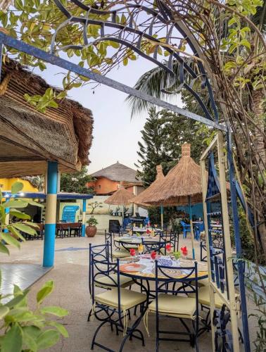 a group of tables with chairs and umbrellas at Villa My Moon - en bord de mer au coeur de Saly in Saly Portudal