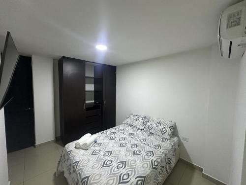 a small bedroom with a bed and a black door at San Luis Apartamento 102 Cúcuta in Cúcuta