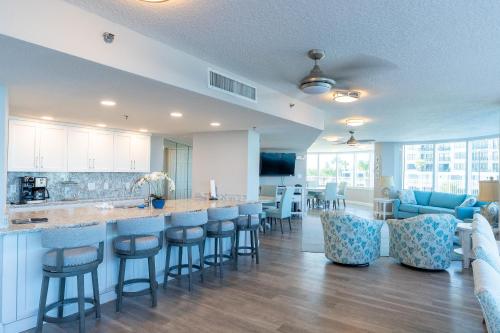a kitchen and living room with a bar with stools at Escape 2 The Beach Daytona Beach FL 2BR 2B as seen on Youtube in Daytona Beach Shores