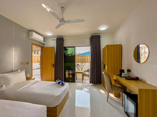a hotel room with a bed and a desk with a computer at Silver Bay Kamadhoo in Kamadhoo