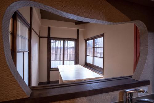 a mirror reflecting a room with two windows at Kiyomizuan 清水庵 車庫2台可 ビフォアアフターの匠 坂田基禎さん改築の京町家 in Kyoto