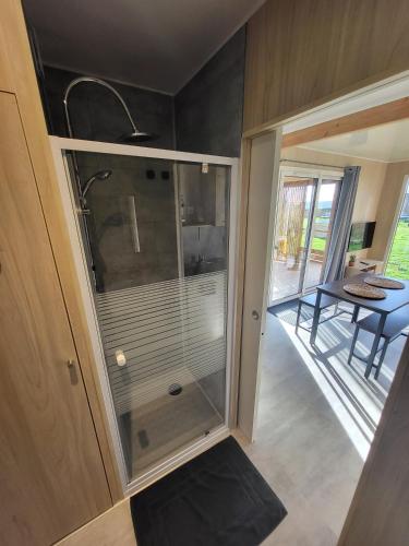 a glass shower in a small room with a table at La cabane des folies in Montmédy