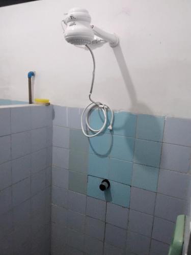 a shower in a bathroom with blue and white tiles at Doce lar do Ipase in São Luís