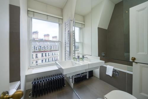 a bathroom with a sink and a window at Victoria Apartments in London