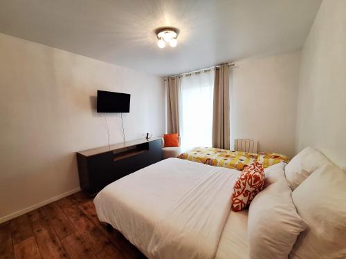 a hotel room with a bed and a television at Studio ALPHA - non-smoking studio - 3min by train to Disney OR 30min walk - 5min walk to "Val d'Europe" train station in Montévrain