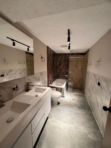 a bathroom with a toilet and a sink and a tub at Hotel Cafe Boutique in Pereira