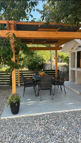 a patio with a table and chairs under a wooden pergola at Villa Ika in Gomila