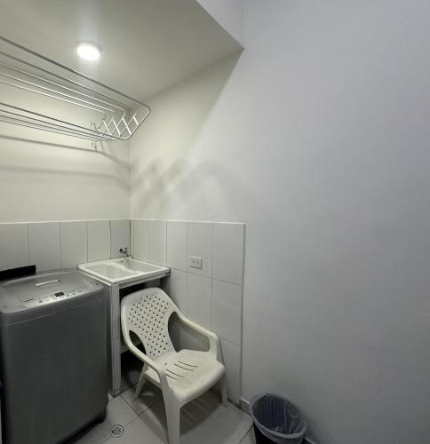 a white bathroom with a chair and a sink at San Luis Apartamento 102 Cúcuta in Cúcuta
