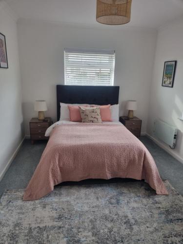 a bedroom with a large bed with a pink blanket at Halwyn View in St Austell