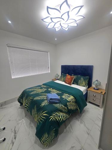 a bedroom with a bed with a blue and green blanket at Heaven in Sutton