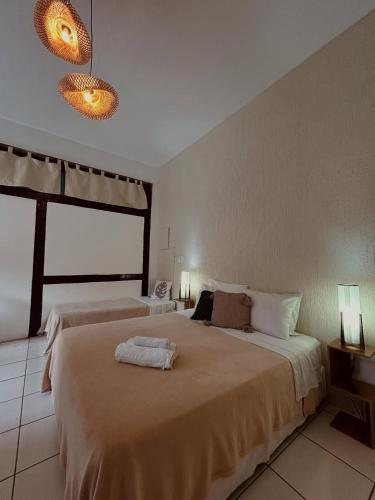 a bedroom with two beds and a large window at Pousada Porto Búzios in Búzios