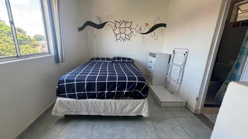 a bedroom with a bed in a room with a window at Kitnet Mobiliada itapua Vila Velha in Vila Velha
