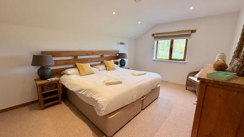 a bedroom with a large bed and a window at The Vineyard in Fowey