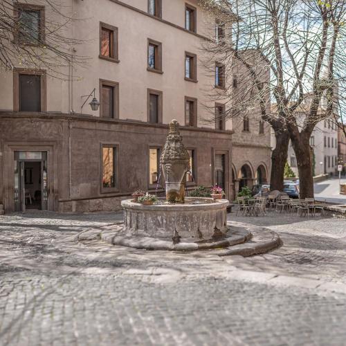 a fountain in the middle of a street in front of a building at Casa Vacanze Ponte del Duomo in Viterbo