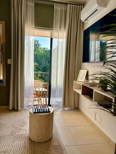 a living room with a large window and a chair at Resort living Selva Escondida II in Puerto Morelos