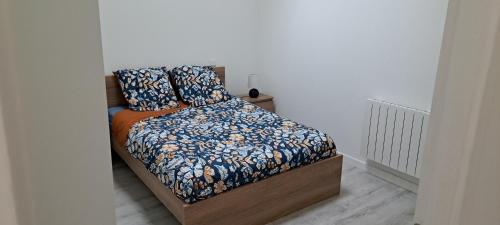 a bedroom with a bed with blue and orange sheets at Gîte du Chemin vert in Taugon