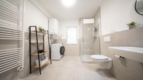 a bathroom with a toilet and a sink and a shower at CharmÖHR Homes in Öhringen