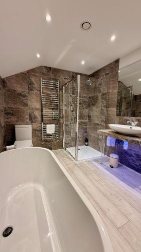a large bathroom with a tub and a shower at The Vineyard in Fowey