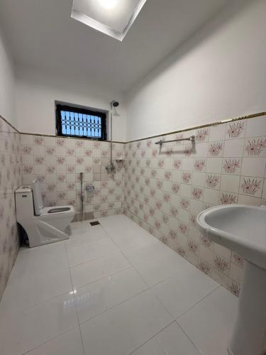 a bathroom with a toilet and a sink at Sunrise Rest House in Islamabad
