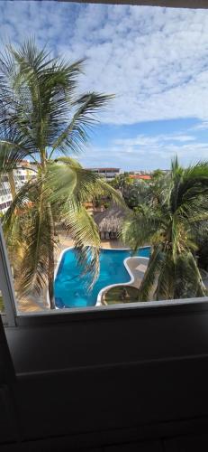 una vista da una finestra di un resort con palme di Aguamarina a Pampatar