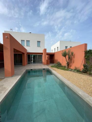 a house with a swimming pool in front of a building at Terra Rossa Residences in Paralimni