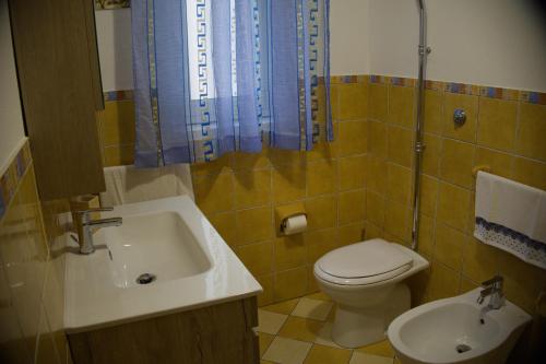 a bathroom with a sink and a toilet and a tub at Casa Luce in Caltabellotta
