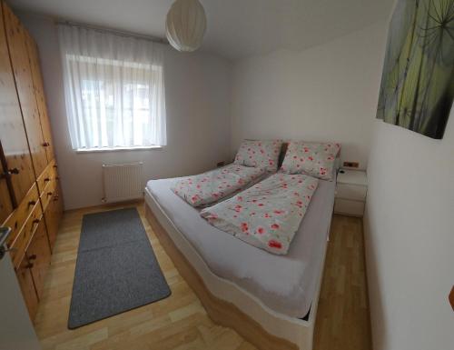 a small bedroom with a bed with flowers on it at Appartement July in Innsbruck