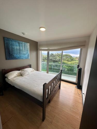 a bedroom with a bed and a large window at Charming Two Bedroom with balcony in San José