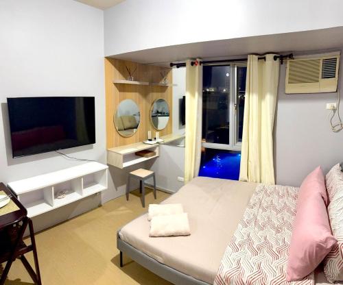 a bedroom with a bed and a desk and a television at Budget Friendly Centrio Tower Studio Unit PoolView in Cagayan de Oro