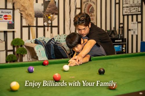 a woman and a young boy playing pool at カラオケ ビリヤード 卓球 ダーツ バーベキュー 4寝室8ベッド16名可 読谷村 沖縄中部 in Yomitan