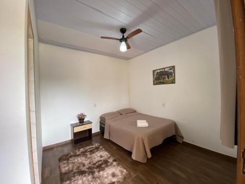 a bedroom with a bed and a ceiling fan at Suites Lara Jackson in Saquarema