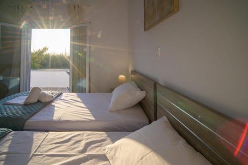 a bedroom with two beds and a window at Arezina's Apartment in Vromolithos