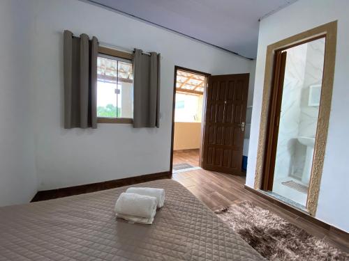 a room with a bed and a large window at Suites Lara Jackson in Saquarema
