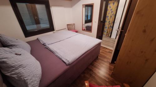 a small bedroom with a bed and a window at Ferienhaus an der Lister in Windebruch