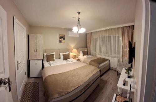 a hotel room with two beds and a television at Gürses Home in Edirne