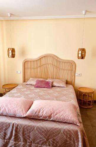 a bedroom with a large bed with pink sheets at La Bodega de la Valduerna 2 in Destriana