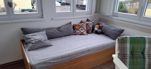 a couch with pillows and a teddy bear on it at Uschi's guest apartment in Ruderting