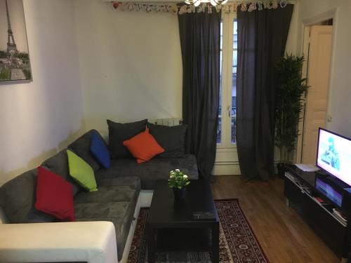 - un salon avec un canapé et des oreillers colorés dans l'établissement Tour Eiffel, Paris Expo - Parc des Princes Apartement, à Paris