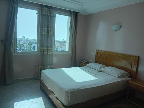 a bedroom with a bed and two windows at HOTEL AZOuR in Agadir