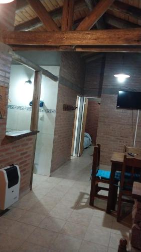 a living room with a television and a table and a room at Cabañas Rio de Oro in Mina Clavero