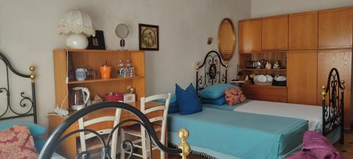 a bedroom with a bed and a dining room at Amabile Guesthouse in Milis