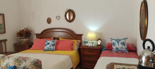 a bedroom with two beds with colorful pillows at Amabile Guesthouse in Milis
