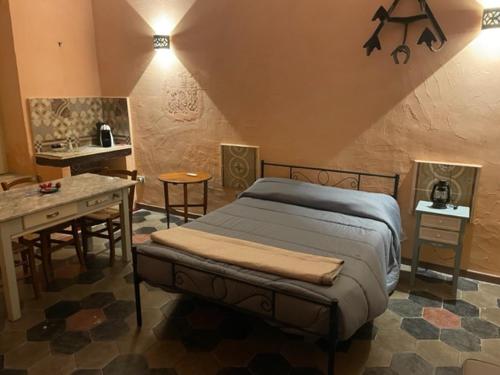 a bedroom with a bed and a table and a kitchen at Casa Mari in Manduria