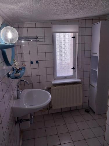 a bathroom with a sink and a window at Fewo Helga in Glowe