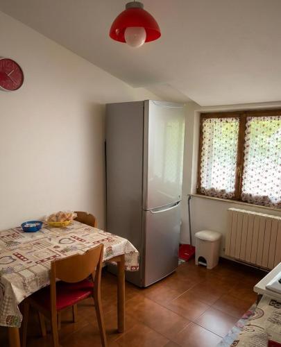 a kitchen with a table and a refrigerator at Rifugio collina del Sacro Cuore in Ascoli Piceno
